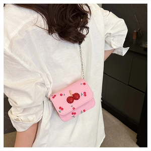 Rosa Mini-Umhängetasche mit Kirschmuster und Strass-Verzierung auf weißer Bluse