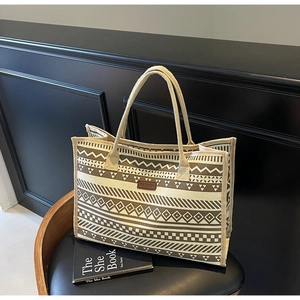 Close-up of geometric canvas tote bag with woven patterns and premium leather patch