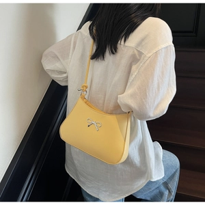 Minimalist yellow crescent underarm bag with silver bow accent and knotted rope strap