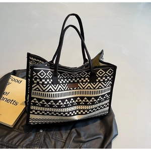 Detail of ethnic canvas tote bag with geometric patterns on a stylish leather background