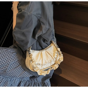 Detail of cream pleated cloud bag with pearl chain and textured jacquard fabric