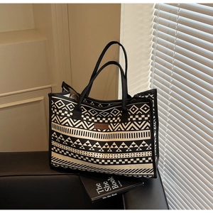 Detail of ethnic geometric canvas tote bag with brown leather fashion logo patch