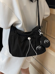 Stylish black nylon crossbody tote bag with drawstring detail and round coin purse accessory