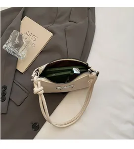 Interior view showing capacity of beige bow shoulder bag with phone and cosmetics