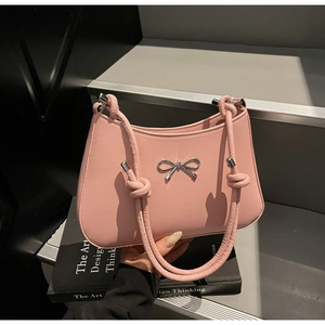 Detail of pink handbag with silver bow metalwork and decorative rope knot handle