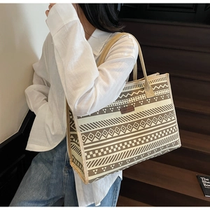 Detail of ethnic geometric print on canvas tote bag with brown leather fashion tag