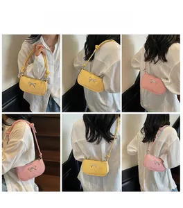 Detail shots of minimalist crescent shoulder bags with silver bow accents in pink and yellow