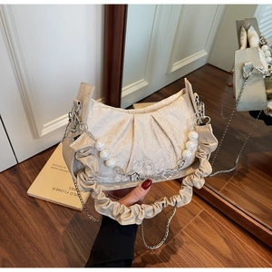 Detail of off-white pleated cloud bag with pearl chain handle and silver floral charm