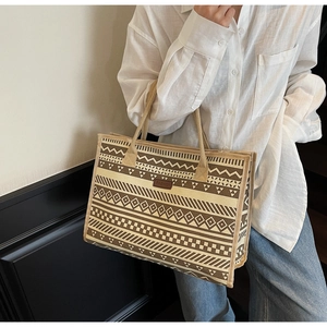 Detail of canvas tote bag with ethnic geometric pattern and braided rope handles