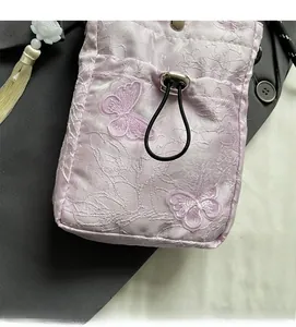 Detail of lavender jacquard fabric with embroidered butterfly and drawstring closure