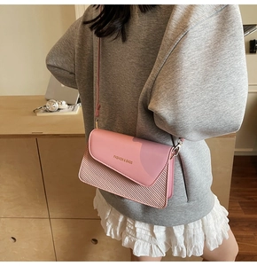 Detail of pink crossbody bag with mixed leather and woven texture in daily use scene