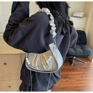 Detail of silver pleated cloud bag with pearl chain and ruffled shoulder strap