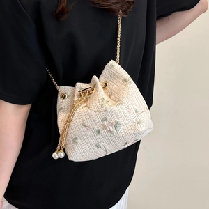 Cream woven bucket bag with floral embroidery and gold chain strap for women