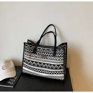 Close-up of black and white geometric ethnic pattern on canvas tote bag with leather tag