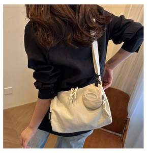 Detail van beige canvas crossbodytas met kleine ronde portemonnee en FANYISSA-logo