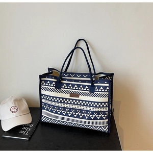 Detailed macro view of retro navy canvas tote bag featuring geometric ethnic patterns