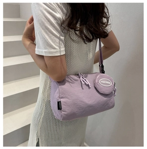 Detailweergave van lichtpaarse canvas crossbodytas met bijpassende ronde mini-muntentas