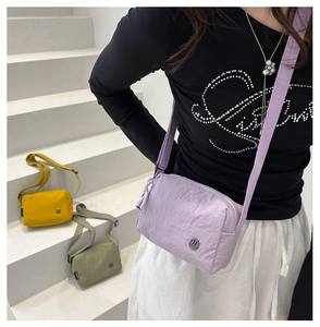 Détail de sacs bandoulière en nylon coloré en lavande, jaune et vert avec sangle large