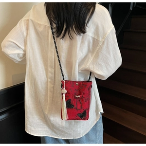 Detail of red Chinese style bucket bag with butterfly embroidery and white tassel