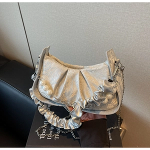 Detail of silver pleated cloud bag featuring large pearls and detachable chain strap