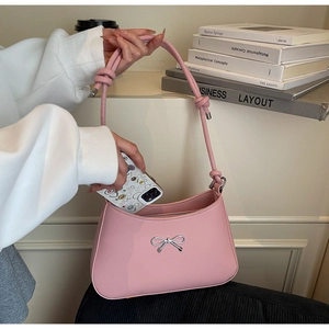 Pink leather shoulder bag with silver bow showing phone fitting inside for capacity
