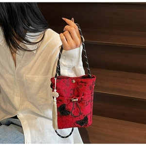 Detail of red Chinese style bucket bag with butterfly embroidery and white tassel