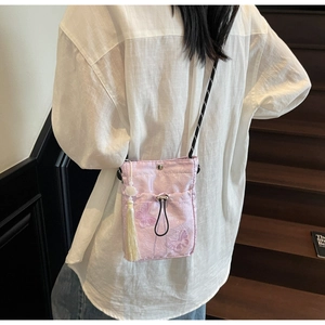 Detail of light purple drawstring bucket bag with butterfly embroidery and long tassels