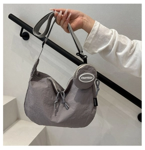 Detail of grey nylon crescent tote with matching round coin pouch and fabric strap