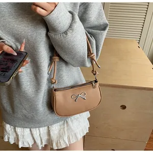 Brown leather underarm bag with silver bow detail and knotted shoulder strap
