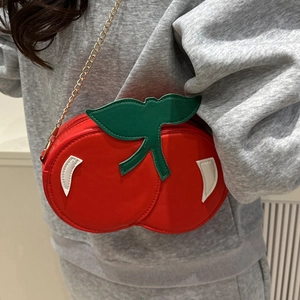 Cute cherry shaped red crossbody bag with green leaves and a golden chain strap