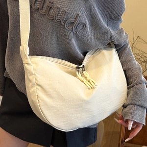 Minimalist beige hobo crossbody bag with woven strap and knot zipper detail