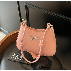 Detail of light pink crescent handbag with silver metal bow and knotted strap