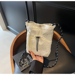 Detail of butterfly embroidery on white Chinese-style bucket bag with tassel