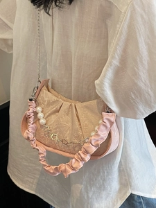 Pale pink pleated cloud bag with pearl chain strap and natural ruched texture style