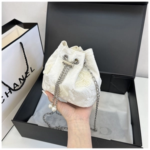 Vue détaillée du sac bourse en dentelle crème avec motifs papillons et cordon de perles