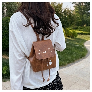 Outdoor shot of vintage brown PU leather cat backpack with drawstring and adjustable straps