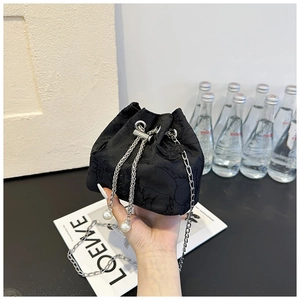 Détail du sac seau en jacquard noir avec cordon, perles blanches et chaîne argentée