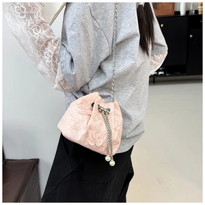 Detailed embroidery of pink lace bucket bag featuring silver chain and pearl drawstrings