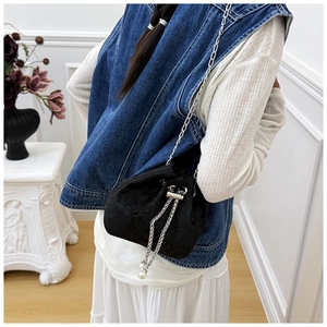 Détail du sac seau noir à cordon avec broderie florale et bandoulière perles
