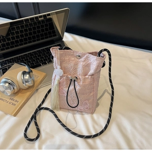 Detailed pink butterfly embroidery and bead tassel on a traditional style bucket bag