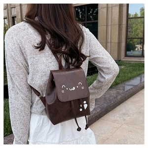 Outdoor shot of mini brown PU cat backpack with cute drawstring closure on model