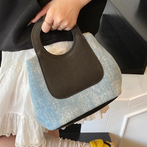 Light blue denim bucket bag with rhinestone details and leather handles for summer style
