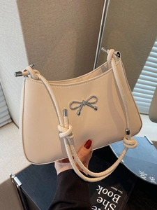 Chic off-white underarm shoulder bag with silver bow accent and knotted strap detail