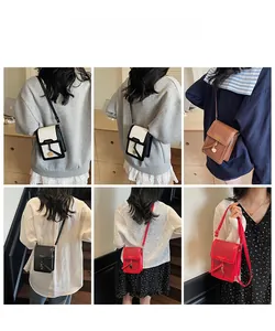 Detail shots of textured leather crossbody phone bags in four classic colors with metal charm