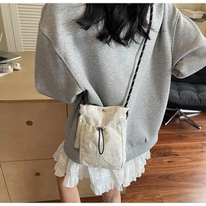 Detail of white butterfly embroidery and drawstring closure on Chinese style bucket bag