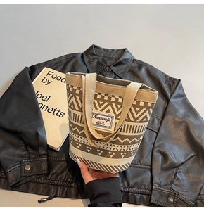 Detail of canvas tote bag with brown geometric tribal patterns and fabric logo patch