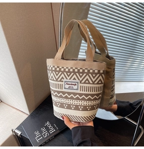 Detail of canvas bucket bag with geometric wave patterns and sturdy brown handles