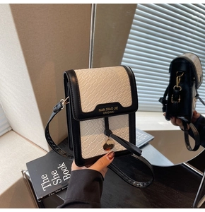Detail of woven textured mini bag with golden logo plaque and black leather trim