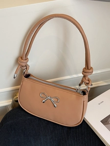 Minimalist caramel moon bag with silver metal bow accent and knotted shoulder strap