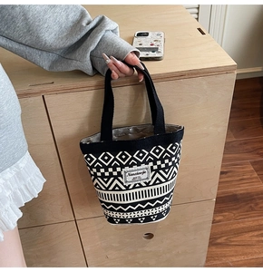 Detail of canvas bucket bag showing ethnic geometric prints and woven brand label